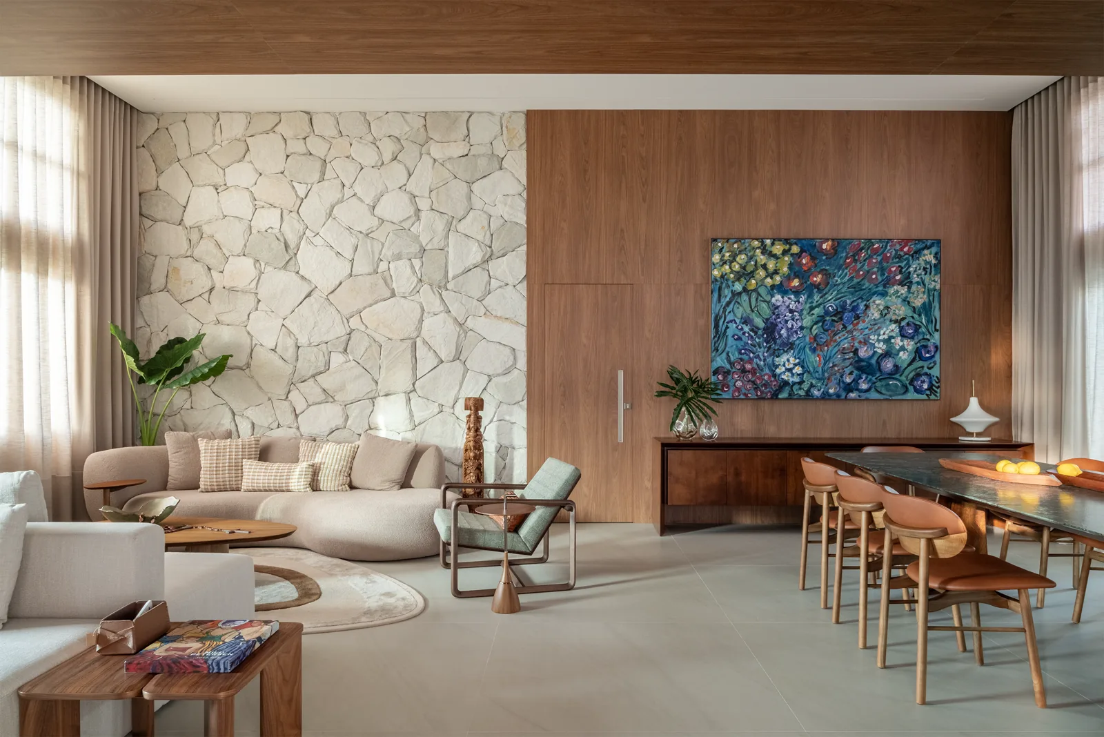 Sala de estar e jantar integrada, com pedra natural e marcenaria em madeira