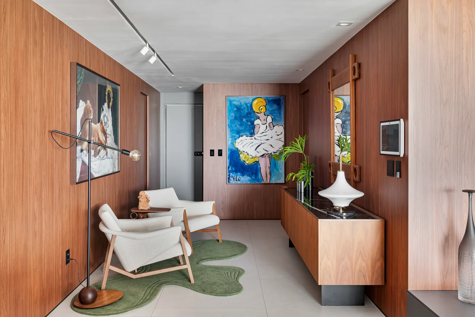 Sala de estar residencial integrada, com madeira, obras de arte e mobiliário contemporâneo